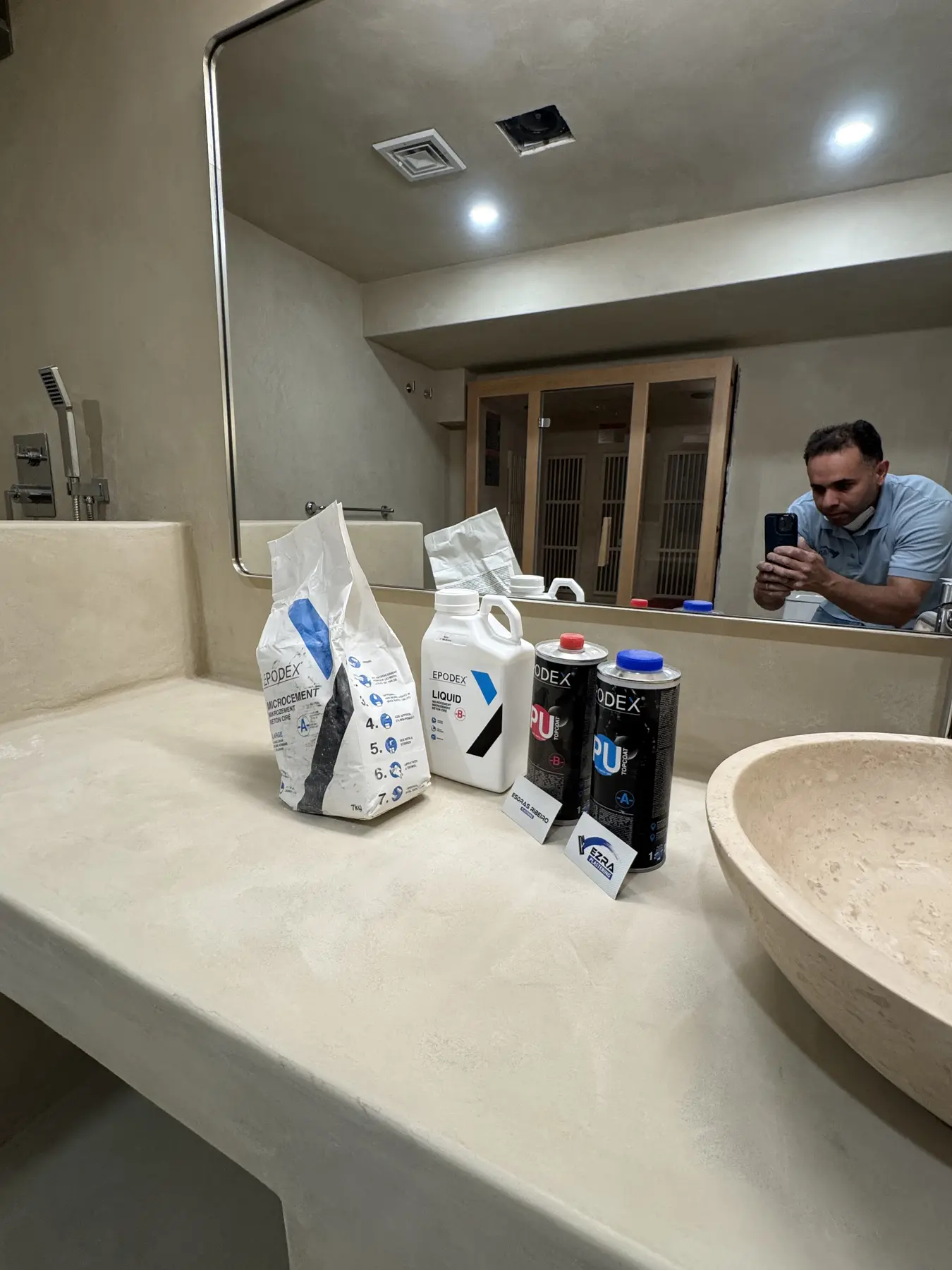 Owner applying microcement on the vanity with materials on site