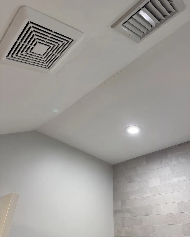 Bathroom ceiling after a seamless plaster repair with the fan grille installed