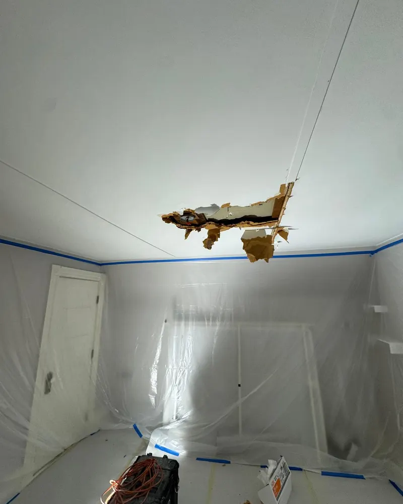 Water damaged ceiling with a torn section